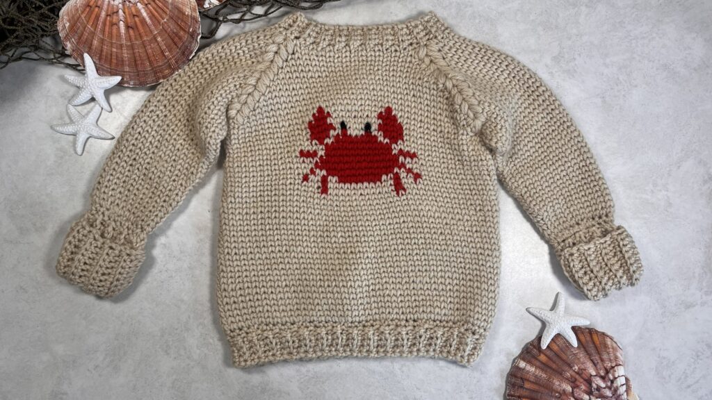 Crabby Baby Sweater made using the Crochet Pattern listed featuring a super cute red crab on a tan sweater